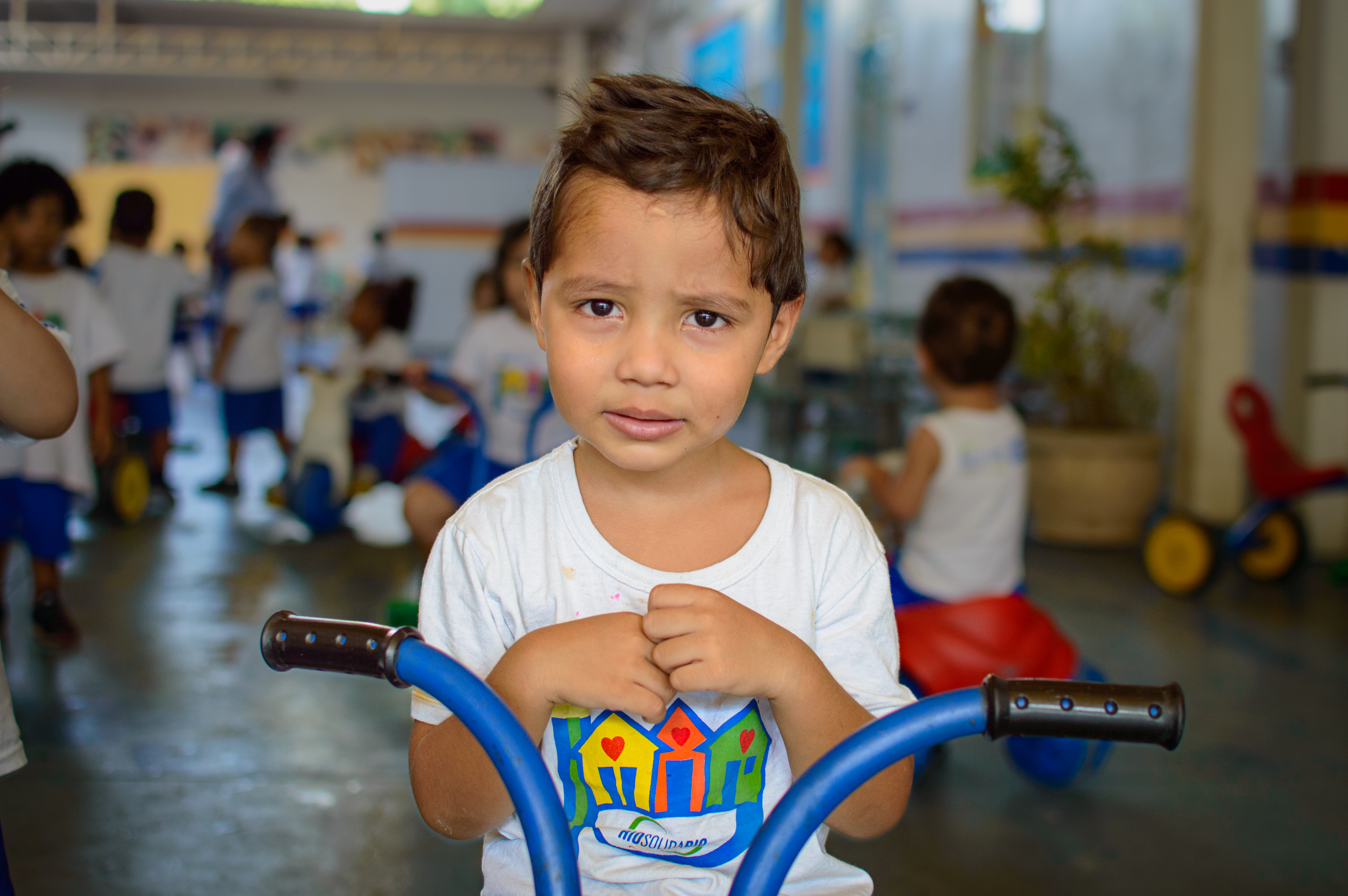 Crianças sorrindo e brincando em um espaço infantil.